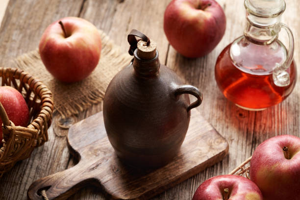 istock Apple cider vinegar in a dark brown bottle with red apples on a table 2171783349