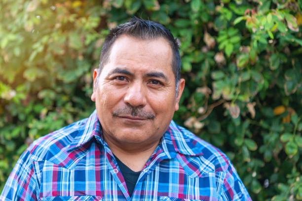 istock Smiling hispanic mature man posing looking at the camera at his home backyard 2171783636