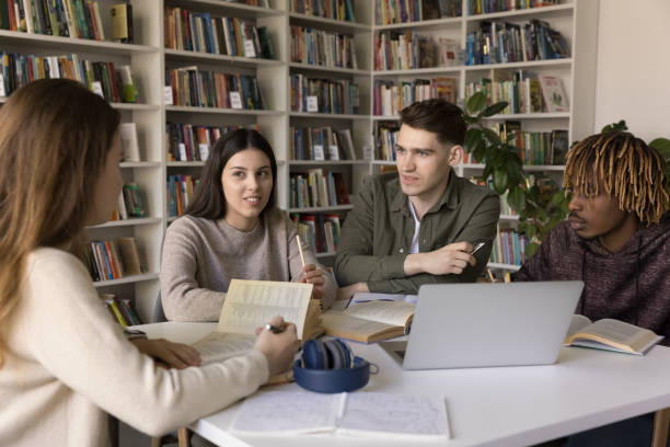 istock Group of young multiethnic college students talking in library 2171786272
