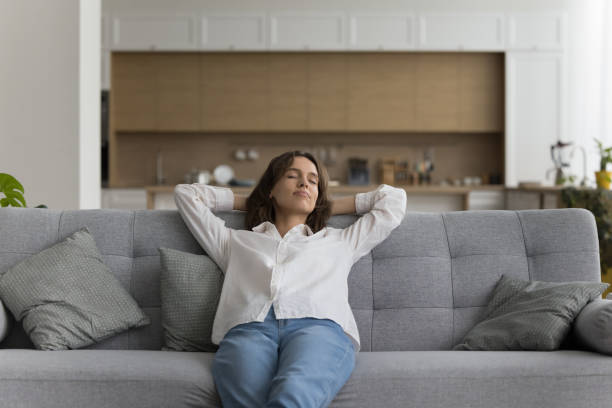 istock peaceful woman relaxing on comfortable sofa in living room 2171786726
