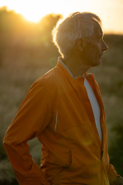 istock Senior man pauses in grasses at sunset 2171790765