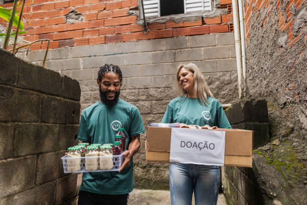 istock Volunteers carrying donation box outdoors 2171792105
