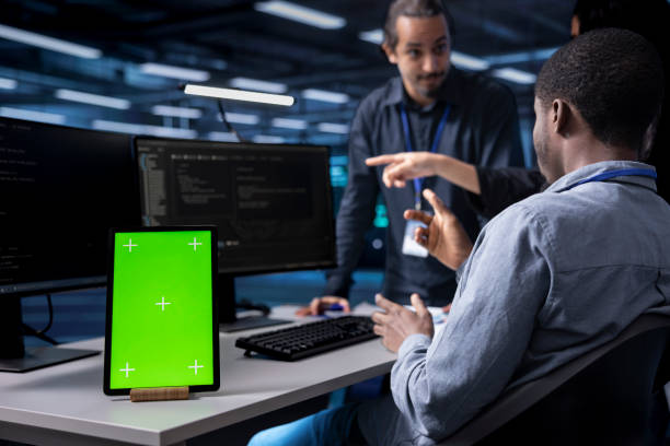 istock Multiethnic team using green screen tablet to oversee servers 2171794519