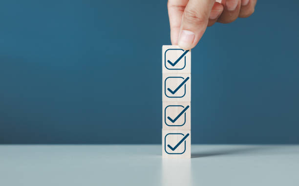 istock Checklist concept, business person checklist tick answer sign in checkbox, validation online questionnaire quality control document, hand putting down the white tick marking wooden cube for checklist. 2171802386