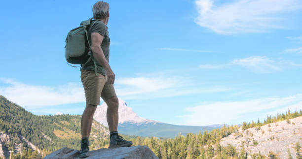istock Mature man on boulder above lake 2171804939