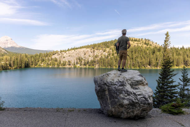 istock Mature man on boulder above lake 2171805148