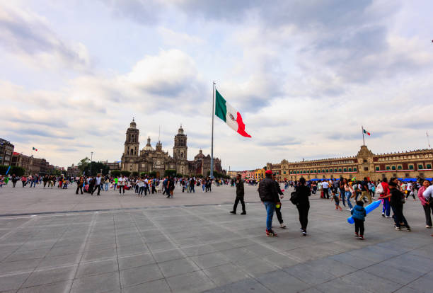 People at Zocalo Square in Mexico City, on a Sunday afternoon, with the National Palace and Metropolitan Cathedral in the background
