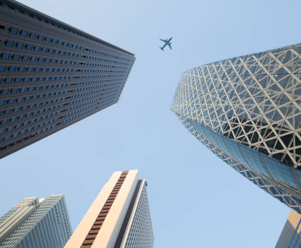 Japan Tokyo, passenger Jet plane passing over head Shinjuku office towers