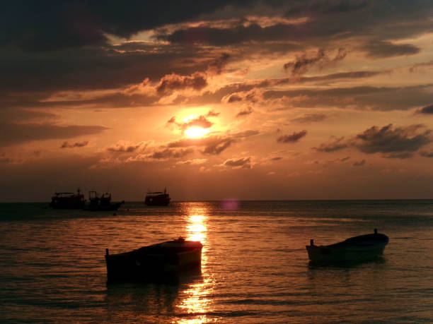 istock Silhouetted Boats at Sunset Over the Ocean 2171815417