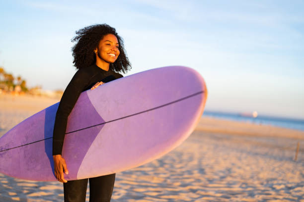 istock Radiant Black Female Surfer with Board on Sandy Shore 2171818574