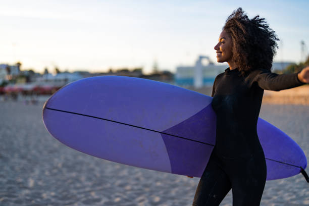istock Joyful Black Female Surfer with Surfboard on Beach 2171818588