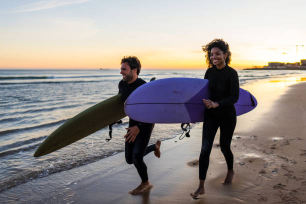 istock Surfing Duo Enjoying a Sunset Beach Run 2171818624