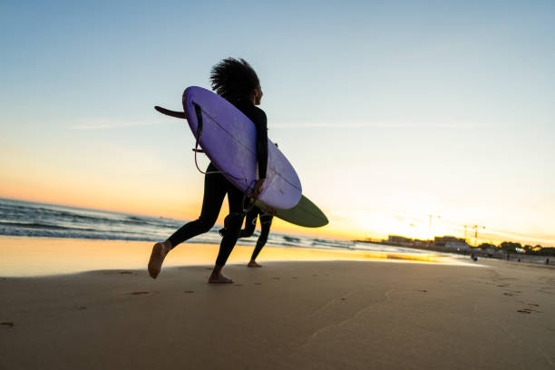 istock Diverse Couple Runs with Surfboards at Beach Sunset 2171818632