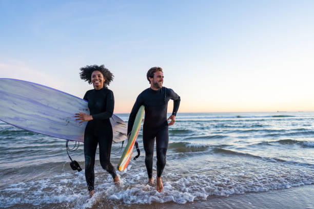 istock Surf Enthusiasts Emerge from Ocean Waves 2171818634