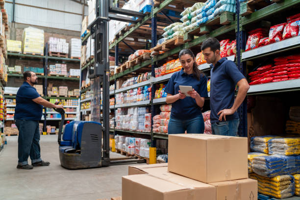 Group of workers at a supermarket moving merchandise using a forklift