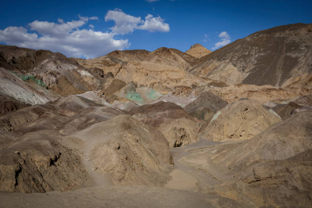 A stunning view of the colorful, mineral-rich rock formations at Artist's Palette in Death Valley, California, with hues of green, pink, and brown caused by mineral oxidation.