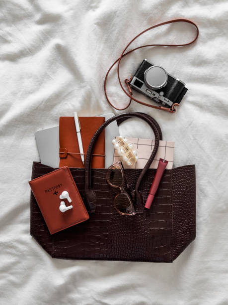 istock Women's leather bag with laptop, notebook, passport, camera, sunglasses, lip gloss on a white background, top view. Travel concept 2171849373