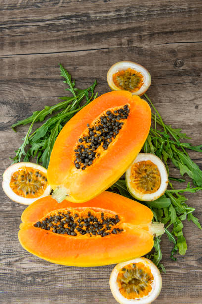 istock Papaya fruit passion fruit and rucola on a dark wooden background 2171850481