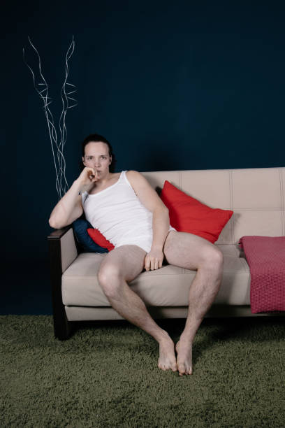 istock A young attractive man is sitting on the sofa and watching TV. 2171859029