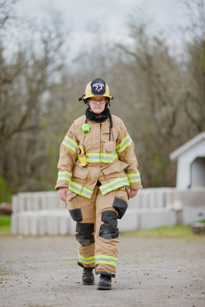 Portraits of a Caucasian female firefighter in her uniform. Shot outdoors with natural light.
