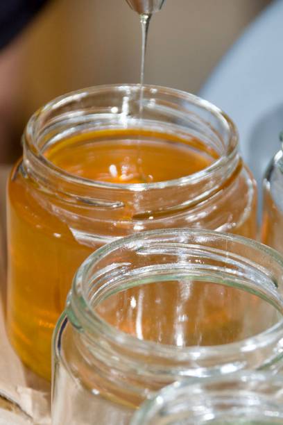 istock Honey pouring into jars 2171880329