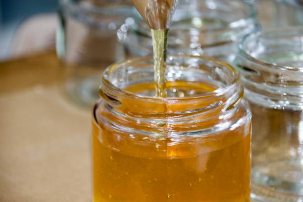 istock Honey pouring into jars 2171880537