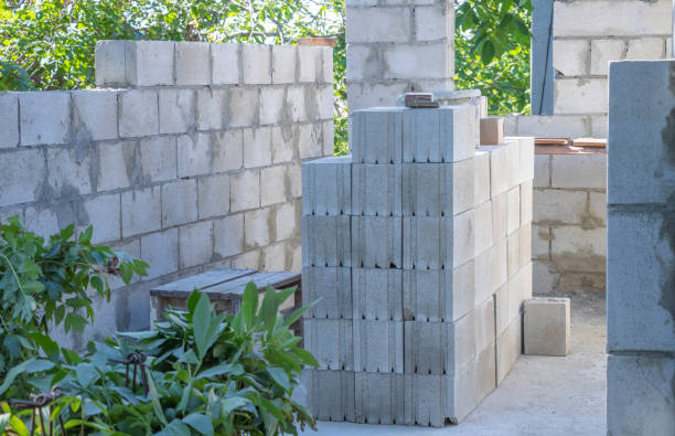 istock A stack of concrete cinder blocks is set up for construction in the backyard, with some greenery and trees visible around it 2171881230