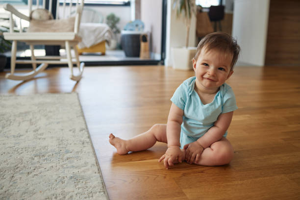 Beautiful toddler child girl wearing blue denim shirt sitting on the floor