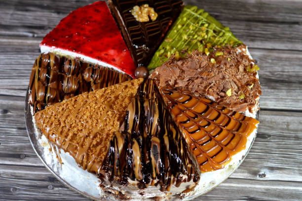 istock Spongy cake pieces with assorted toppings and fillings with whipped cream, chocolate paste, chunks and balls of chocolates, biscuit sauce and paste 2171888377