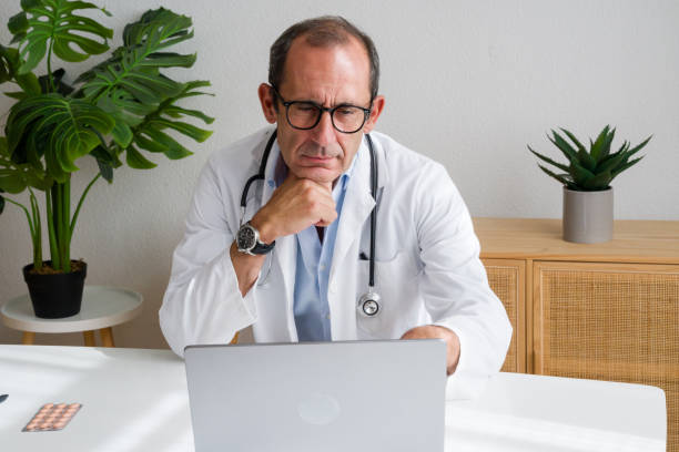 istock Doctor thinking while working with laptop in medical office 2171893611