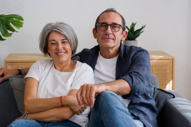 istock Happy senior couple relaxing on sofa at home 2171894407