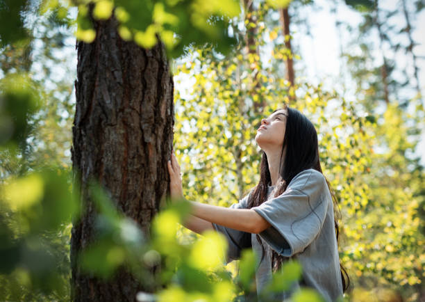istock A young girl hugs a tree in the forest. 2171894778