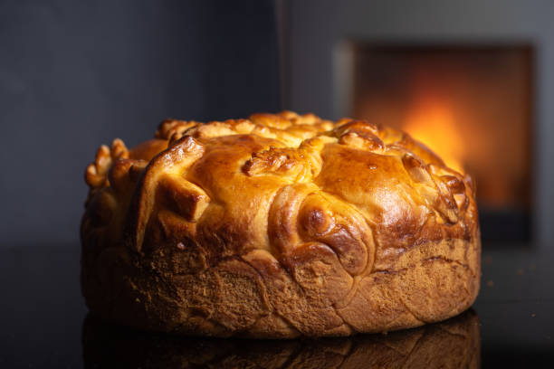 istock Traditional Orthodox Christmas Slava Bread: Round bread loaf on dark surface with warm background. 2171897565