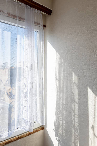 istock tulle curtains on home window and wall lit by sun 2171898068