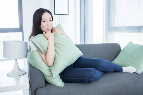 istock A woman relaxing on a couch with a pillow 2171901741