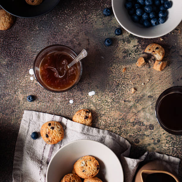 A cup of coffee with homemade cookies and blueberries