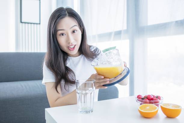 istock Asian woman making orange juice in the kitchen 2171907118