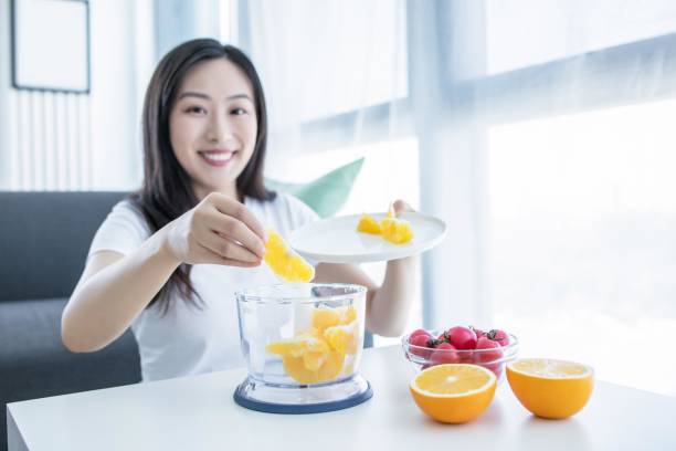 istock Asian woman making orange juice in the kitchen 2171907377