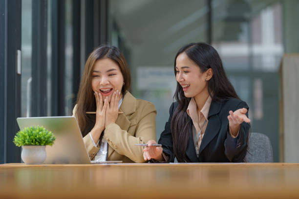 istock Two beautiful Asian businesswomen working together using a laptop computer work together consult and advise on working together to plan work on a new product. 2171913886