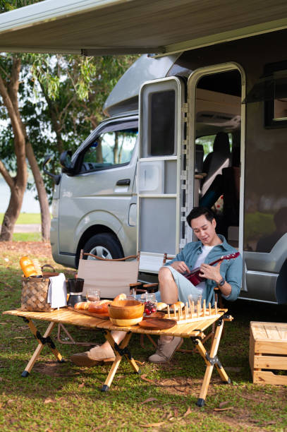 istock Mid aged Asian man joyful picnic adventure with camper van 2171915064