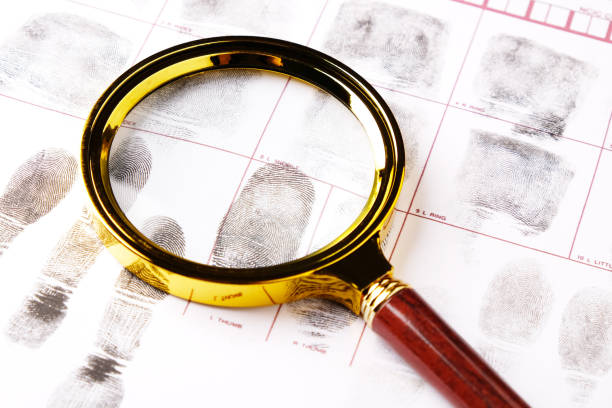 istock magnifying glass on fingerprint card background close-up, forensic fingerprint examination 2171915251
