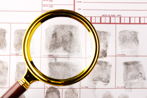 istock magnifying glass on fingerprint card background close-up, forensic fingerprint examination 2171915258