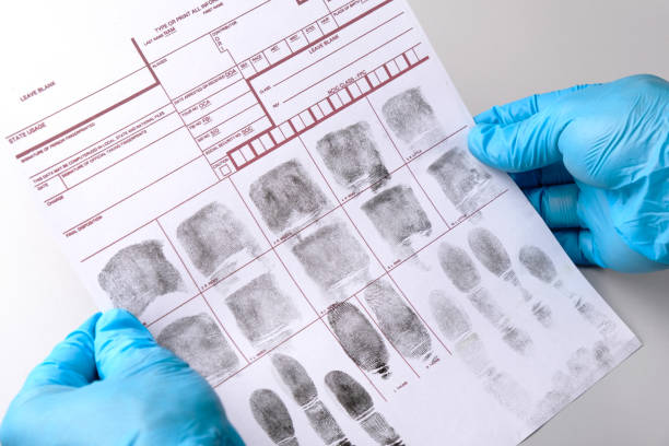 istock Forensic expert criminologist examines fingerprint card with magnifying glass, holds in gloved hands close-up, fingerprint examination 2171915280