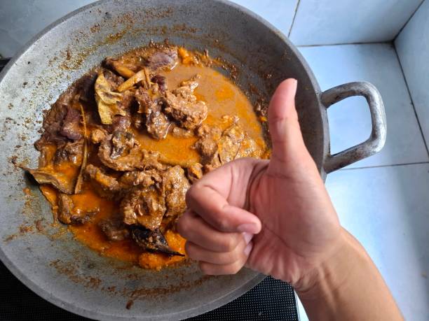 istock Hand pointing at Rendang, an Indonesian meat-based food produced from a long-term low temperature cooking process using various spices and coconut milk 2171919524