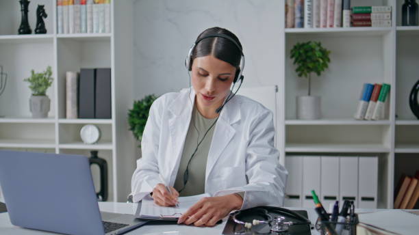 istock Consultant providing telemedicine service in headset writing notes closeup. 2171925277