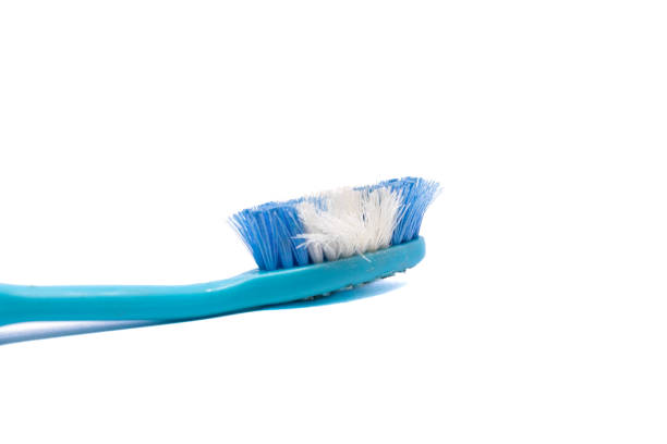 A detailed image of a worn blue toothbrush with frayed bristles, isolated on a clean white background, symbolizing dental care and hygiene.