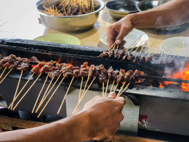 istock Grilled Satay Skewers Over Charcoal With Hands Preparing 2171927953