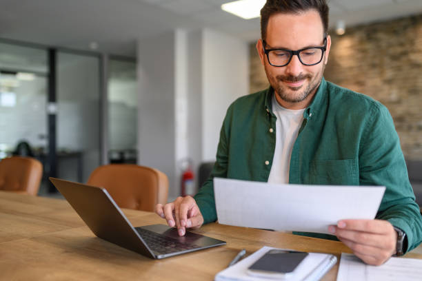 istock Portrait of handsome manager auditing financial document and report over computer at his workplace 2171932909