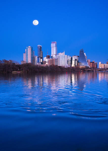 A perfect sunset with pinks and blues across the colorful sky large green escape public green space at Zilker Park with landmark skyline cityscape view of Austin , Texas , USA