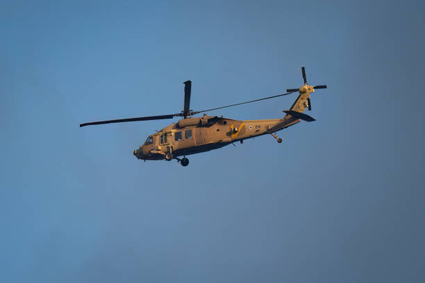 Jerusalem, Israel - July 14th, 2024: An Israeli air force black hawk helicopter at flight in a partially cloudy sky.